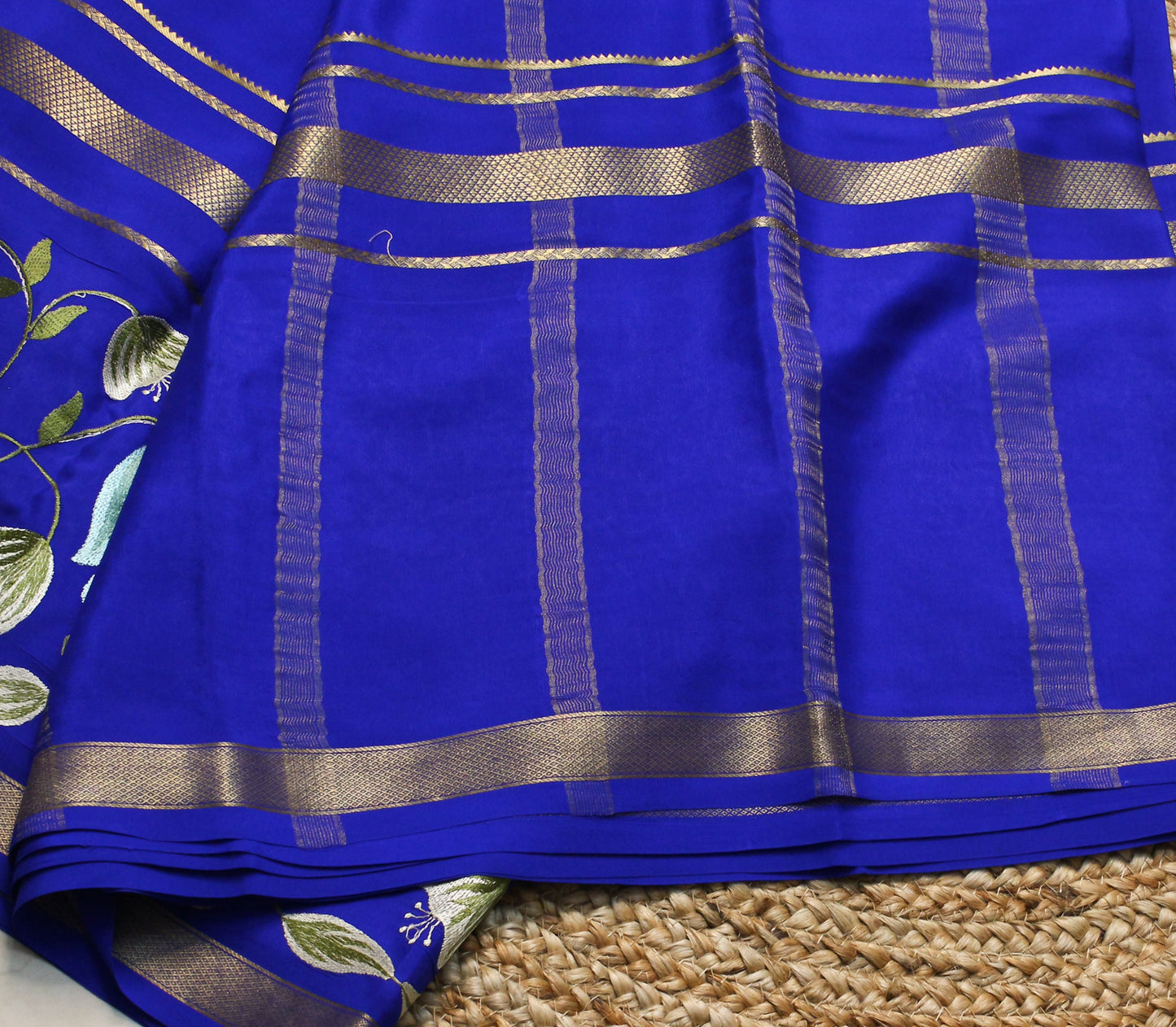 Blue fabric with gold stripes on a woven surface