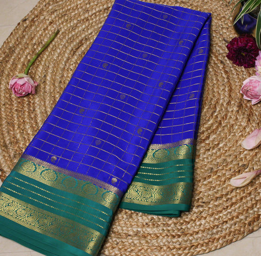 Blue and green saree with gold patterns on a woven surface